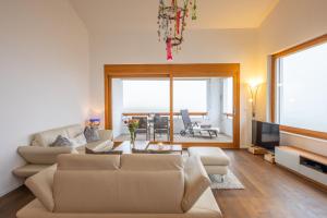 a living room with a couch and a tv at Edelweiss Ferienwohnung, Panoramablick in Flims