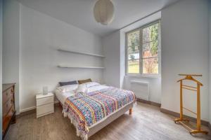 a white bedroom with a bed and a window at Le Prieuré in Grenoble