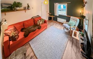 a cat laying on a red couch in a living room at 2 Bedroom Stunning Home In Grsmark in Gräsmark