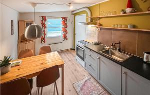 a kitchen with a sink and a wooden table at 2 Bedroom Stunning Home In Grsmark in Gräsmark