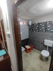 a small bathroom with a toilet and a shower at Vasant Bamboo Cottage in Maheshwar