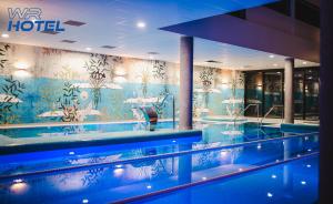 a hotel with a swimming pool with a mural on the wall at WR SPORT HOTEL & SPA - Centrum Sportu i Rozrywki in Rzeszów