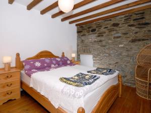 a bedroom with a bed and a stone wall at Yr Hen Gof in Mathry