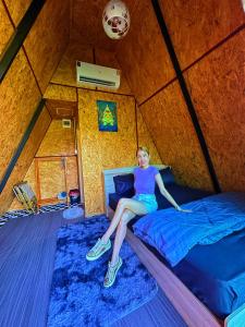 a woman sitting on a bed in a yurt at หัวน้ำฮิลล์huanamhill in Pua