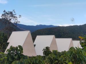 a row of white buildings with mountains in the background at หัวน้ำฮิลล์huanamhill in Pua