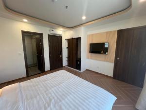 a bedroom with a large bed and a flat screen tv at Tanya Phu Quoc Hotel in Phu Quoc +20 photos