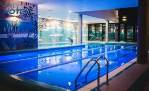 a swimming pool with blue lights in a hotel at WR SPORT HOTEL & SPA - Centrum Sportu i Rozrywki in Rzeszów