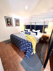 a bedroom with a bed with a blue and white comforter at 7 - Central Studio - King Bed - Bike Facilities in Merthyr Tydfil