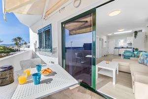- un salon avec une table et une assiette de nourriture dans l'établissement Home2Book Modern Apt Puerto del Carmen, Terrace, à Puerto del Carmen