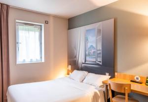 سرير أو أسرّة في غرفة في B&B HOTEL Limoges 1