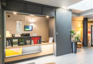 a lobby of a restaurant with a cash counter at B&B HOTEL Limoges 1 in Limoges