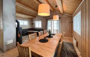 a wooden dining room with a table and a fireplace at 6 Bedroom Nice Home In Nord-torpa in Nord Torpa