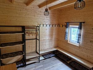 um quarto com paredes e prateleiras de madeira e uma janela em Chaty u lesa em Velké Hamry