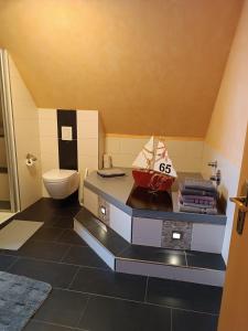 a bathroom with a toilet and a counter with a sink at Gästehaus Atrico Schleuse Wg 1 in Surwold +9 photos