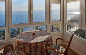 einen Tisch und Stühle in einem Zimmer mit Fenstern in der Unterkunft Beach Front Apartment In Algarrobo-costa With Outdoor Swimming Pool in Algarrobo-Costa