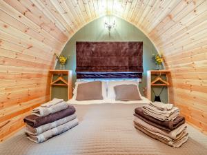 a bedroom with a large bed in a wooden room at The Hive - Uk45565 in Longford