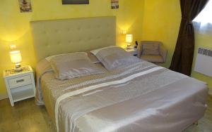 ein Schlafzimmer mit einem großen Bett mit zwei Lampen und einem Stuhl in der Unterkunft Logis Hotel des Granges in Arles