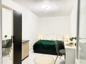 1 dormitorio con 1 cama, escritorio y sillas en Apartament - Voineasa en Voineasa