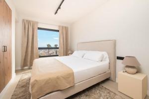 ein weißes Schlafzimmer mit einem Bett und einem Fenster in der Unterkunft Luxury piso Nijota NEW in Santa Cruz de Tenerife