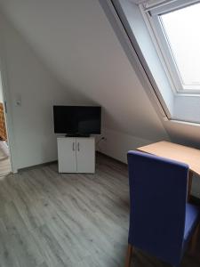 a room with a desk and a tv and a table and a chair at Gästehaus Atrico Schleuse Wg 1 in Surwold