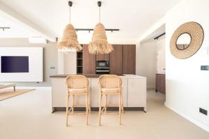 eine Küche mit 2 Stühlen und eine Kücheninsel in der Unterkunft Luxury piso Nijota NEW in Santa Cruz de Tenerife
