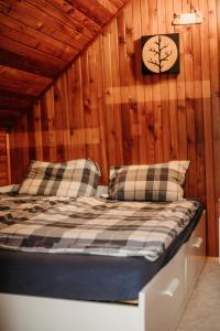 ein Schlafzimmer mit einem Bett in einer Holzwand in der Unterkunft Chata U Svahu in Němčičky