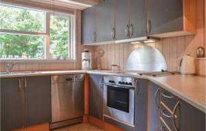 una cocina con electrodomésticos de acero inoxidable y una ventana en Cozy Home In Grsted With Wifi en Græsted