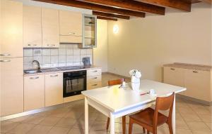 una cucina con tavolo e sedie bianchi di Stunning Apartment In Lecce Nei Marsi With Wi-fi a Gioia dei Marsi
