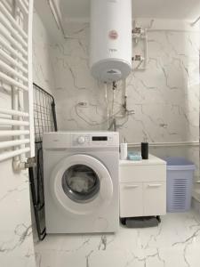lavadero blanco con lavadora en Apartament - Voineasa, en Voineasa