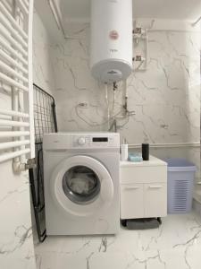 a white laundry room with a washing machine at Apartament - Voineasa -Aproape de Domeniul Schiabil in Voineasa
