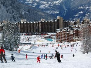 un grupo de personas esquiando por una pista de esquí cubierta de nieve en Appartement Plagne Bellecôte, 2 pièces, 5 personnes - FR-1-181-952, en Plagne Bellecôte