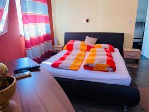 uma cama com almofadas coloridas num quarto em Borostyán Apartmanház em Mórahalom