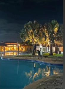 una piscina con palme di fronte a un edificio di Búzios Beach Resorts a Búzios