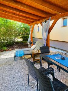 patio z kanapą, krzesłami i parasolem w obiekcie Borostyán Apartmanház w mieście Mórahalom