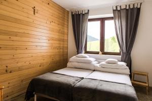 een slaapkamer met een bed en een raam met handdoeken bij Honey Inn in Kamianna