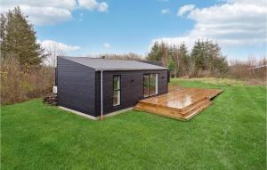 una casita negra con una terraza de madera en un campo en Amazing Home In Spttrup With Wifi, en Spottrup