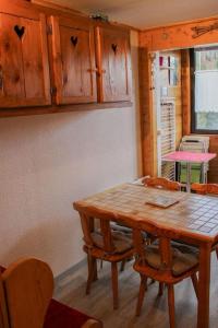 a kitchen with a wooden table and chairs at T1 Cosy Pleine station de ski in Bellevaux