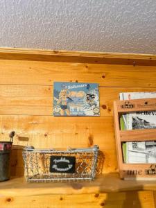 a shelf with a book on a wooden wall at T1 Cosy Pleine station de ski in Bellevaux
