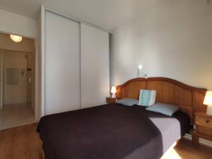 um quarto com uma grande cama preta e 2 almofadas em Appartement Juan les Pins, 2 pièces, 4 personnes - FR-1-252-155 em Juan-les-Pins