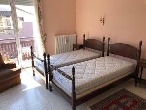 two beds sitting in a room with a window at Villa T5 avec jardin, 100m plage, clim, WiFi, pour 8-10 pers, Le Barcarès - FR-1-81-524 in Le Barcarès