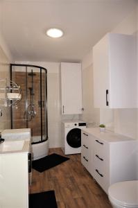 y baño blanco con ducha y aseo. en Apartament Barskich, en Rzeszów