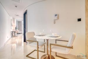 a dining room with a white table and chairs at Spacious Studio at Sky Gardens DIFC by Deluxe Holiday Homes in Dubai
