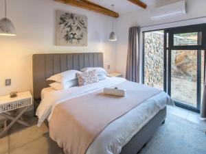a bedroom with a large bed and a large window at Ludicks Farm in Montagu