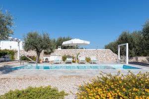 una piscina con sillas y una sombrilla en un patio en Kalathos Dream Villas, en Kalathos