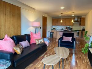 a living room with a couch and a table and a kitchen at Durham City Luxury Apartment in Durham