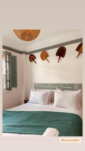 1 dormitorio con 1 cama grande con manta verde en Riad Gasämbre Touareg, en Marrakech