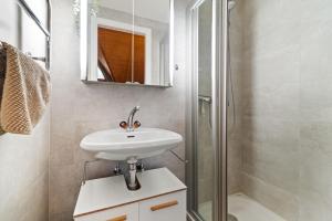a bathroom with a sink and a shower at Cosy appartement lumineux et spacieux à Charmey in Charmey