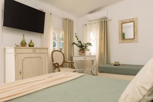 1 dormitorio con 1 cama y TV en la pared en PRETTY SPITI Holiday Home, en Laganas