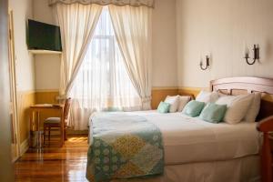 a bedroom with a large bed and a window at Hotel Di Torlaschi in Valdivia