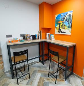 a table and two chairs in a room with an orange wall at DORM BG pet-friendly Aparthotel in Stara Zagora